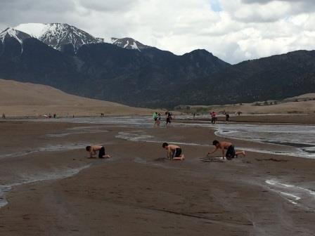 kids playing in the sand and river great sand dunes national park colorado